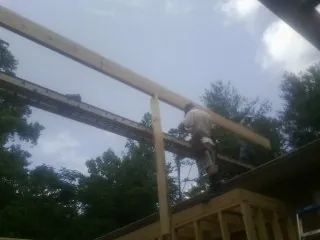 Carpenter setting a ridge beam over a new addition frame — Ice Dam Removal by Roofing Brothers in Oley