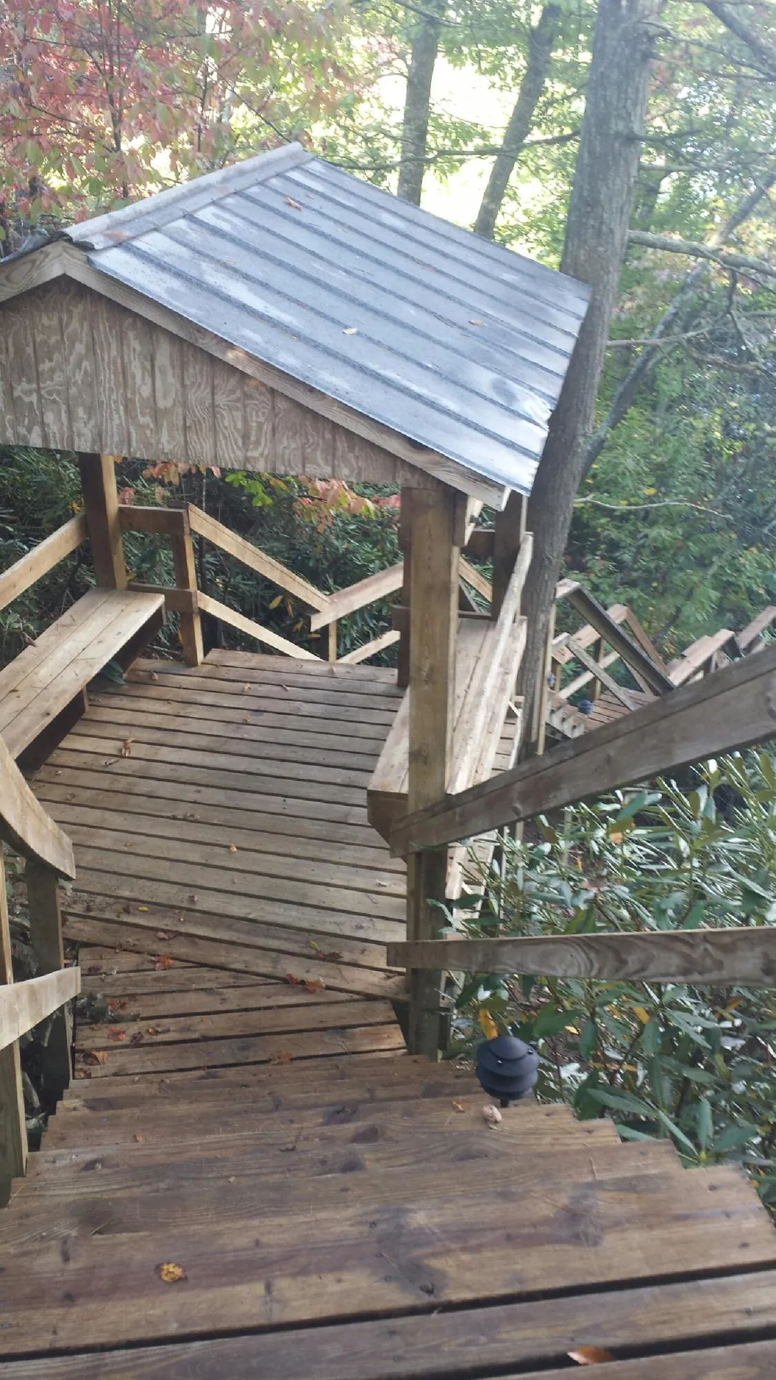 Metal roofed shelter over wooden steps on a wooded walkway — Skylight Repair & Installation work by our crew in Oley