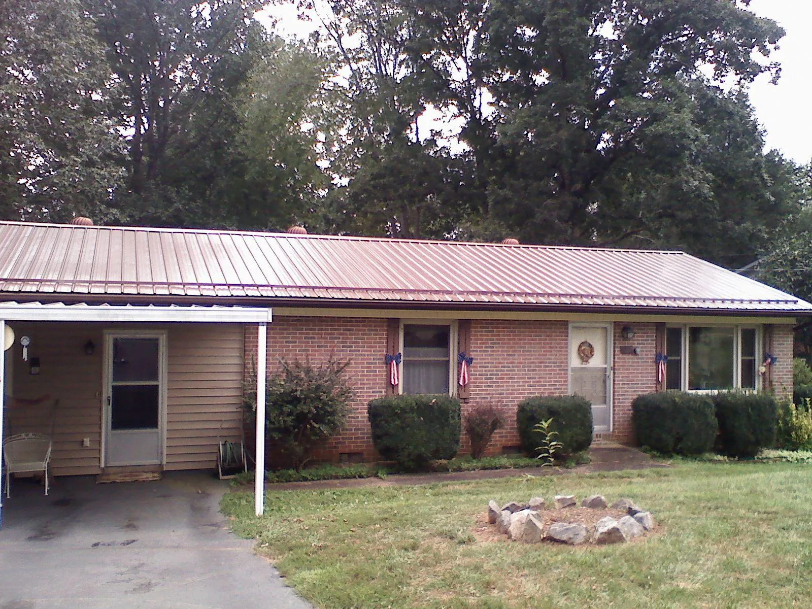 Bronze metal roof and carport on a brick ranch home — Roof Repair work by our crew in Oley